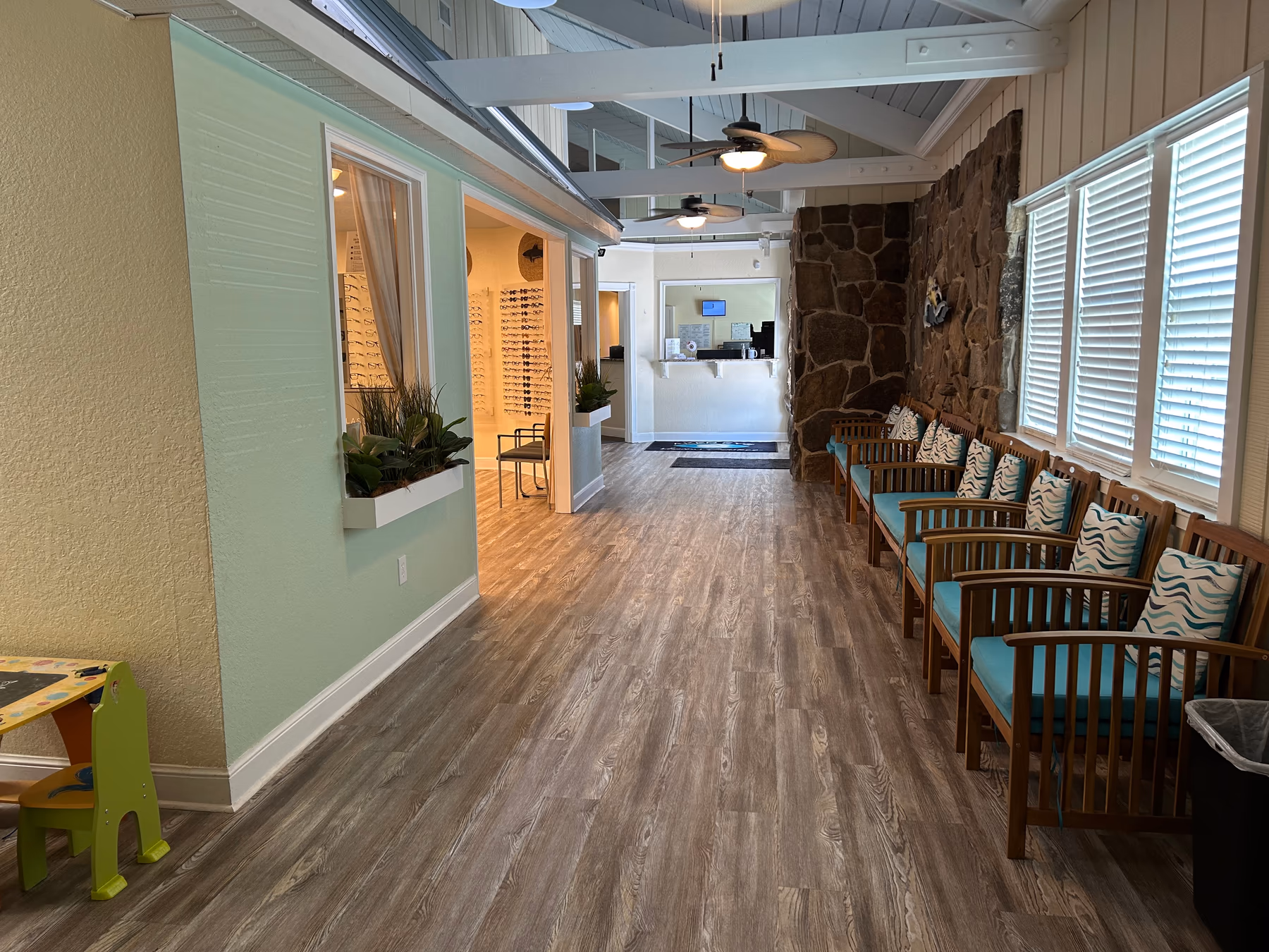 Inside Aker Eye Playalinda today: the hallway past the waiting room toward the frame wall and the front desk